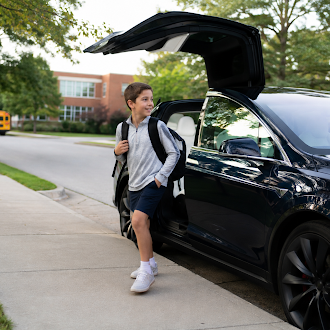 A student stepping out of a Wayven vehicle at school